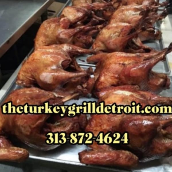 Multiple golden-brown roasted turkeys on metal trays, ready to be served at The Turkey Grill.